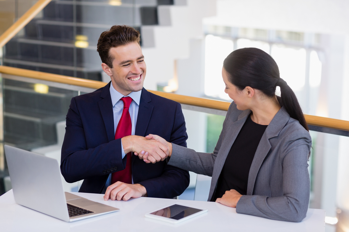 Businessman shaking hands with colleague at desk Silicon Sanskriti Technologies Silicon Sanskriti Technologies